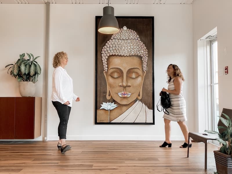 Val Hemminger from Pathway Legal BC meets a client under a giant Buddah painting