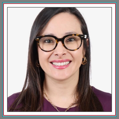 Professional headshot of Viviana Vargas, Floating Pack Coordinator at Pathway Legal, smiling warmly with long dark hair, tortoiseshell glasses, and gold hoop earrings, wearing a deep plum top against a clean light grey background.