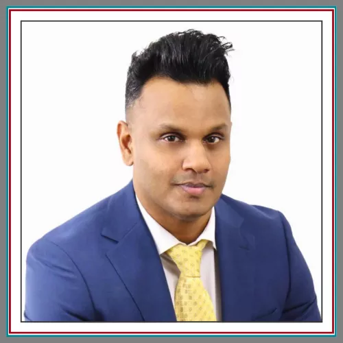 Professional headshot of Arun Madhavan, family lawyer at Pathway Legal, wearing a navy blue suit and gold patterned tie against a clean white background, with a confident and polished presence.
